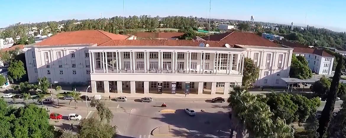 El Pabellón Argentina de Ciudad Universitaria en un día soleado visto desde el frente con una cámara en un drone