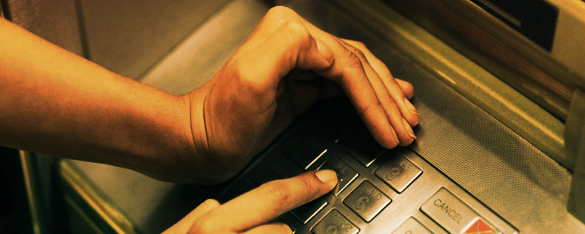 las manos de una persona operando un cajero automático