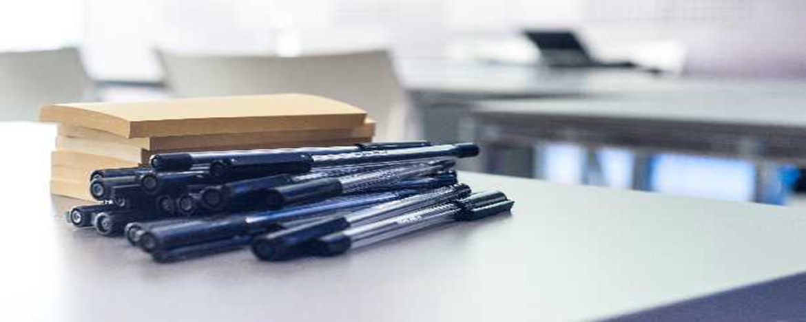 lapiceras y cuadernos sobre escritorio